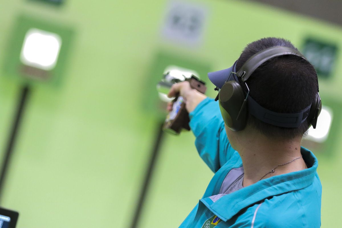 Sportschützin schießt einarmig und freistehend mit der Luftpistole auf zehn Meter