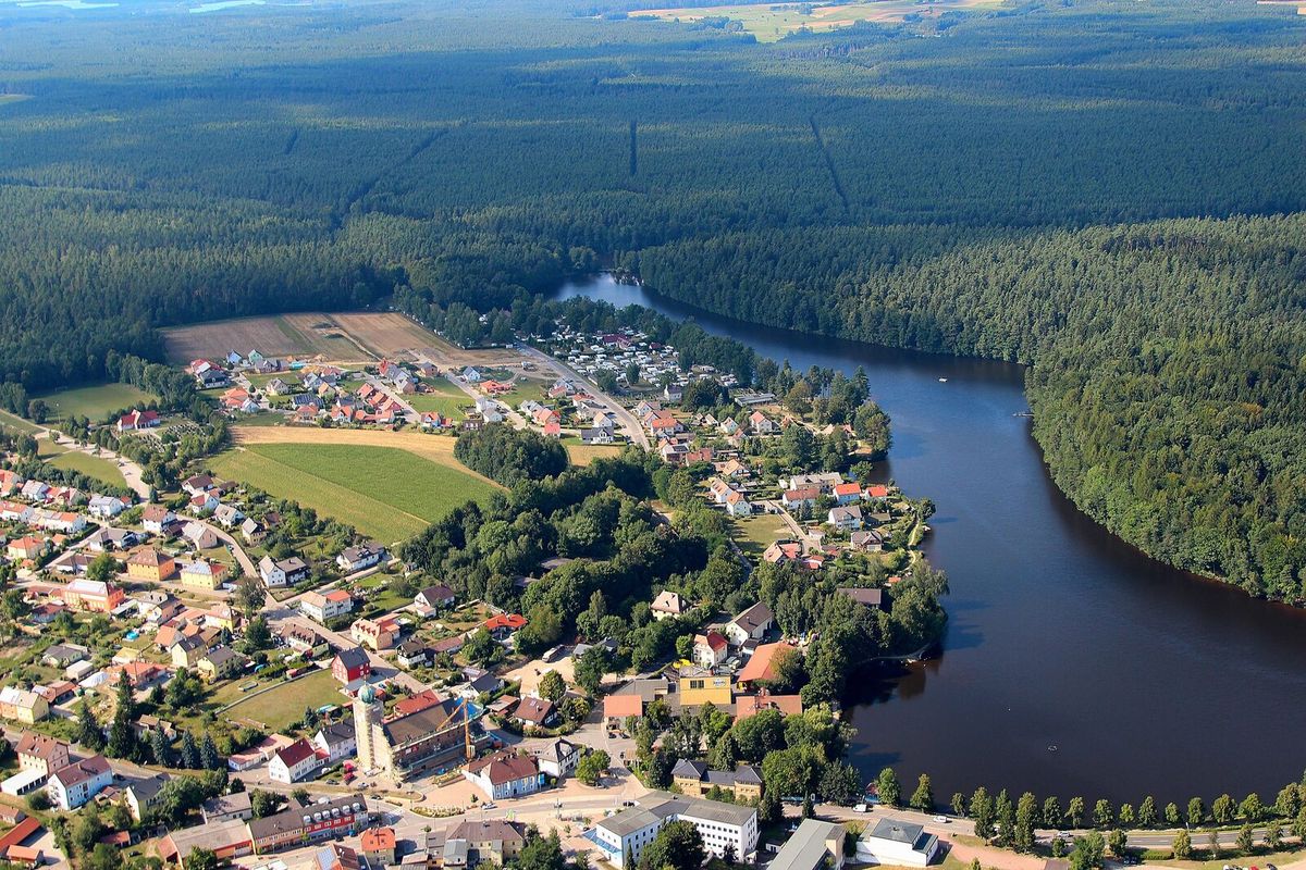 Luftbild von Bodenwöhr mit dem Hammerweiher, umgeben von großen Nadelwäldern