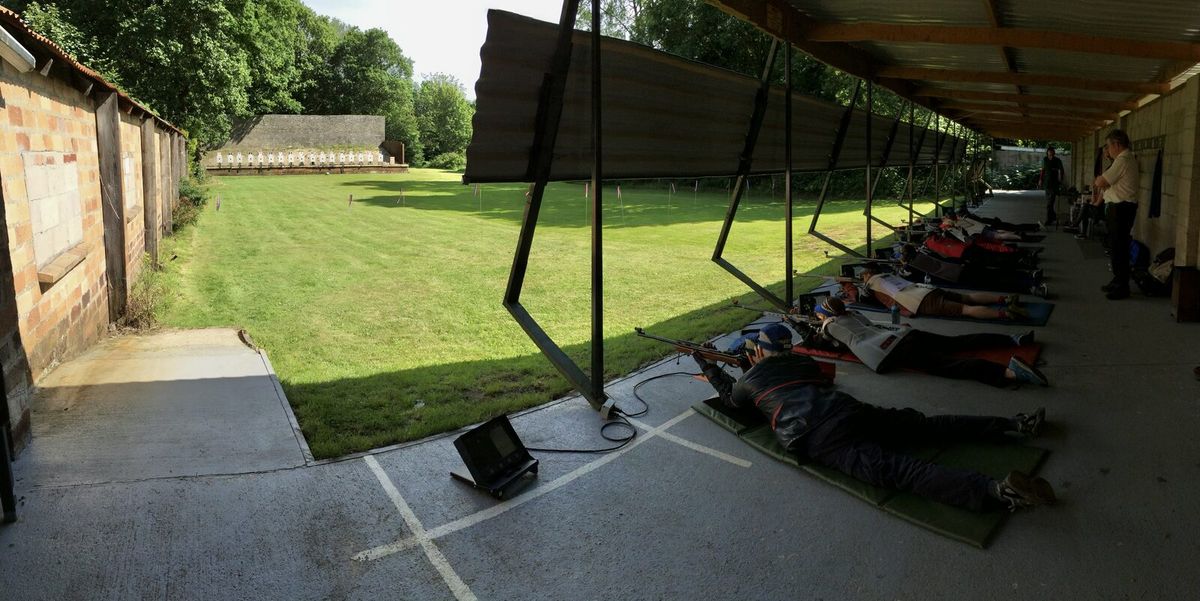 Überdachter Schießstand mit Schützen in Bauchlage und Zugscheiben im Hintergrund
