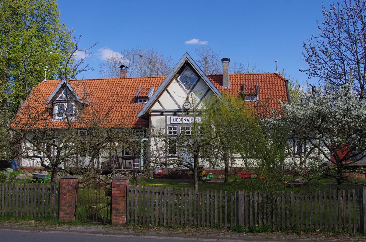 Backsteinernes Empfangsgebäude des Bahnhofs Liebenau mit Bahnsteigüberdachung