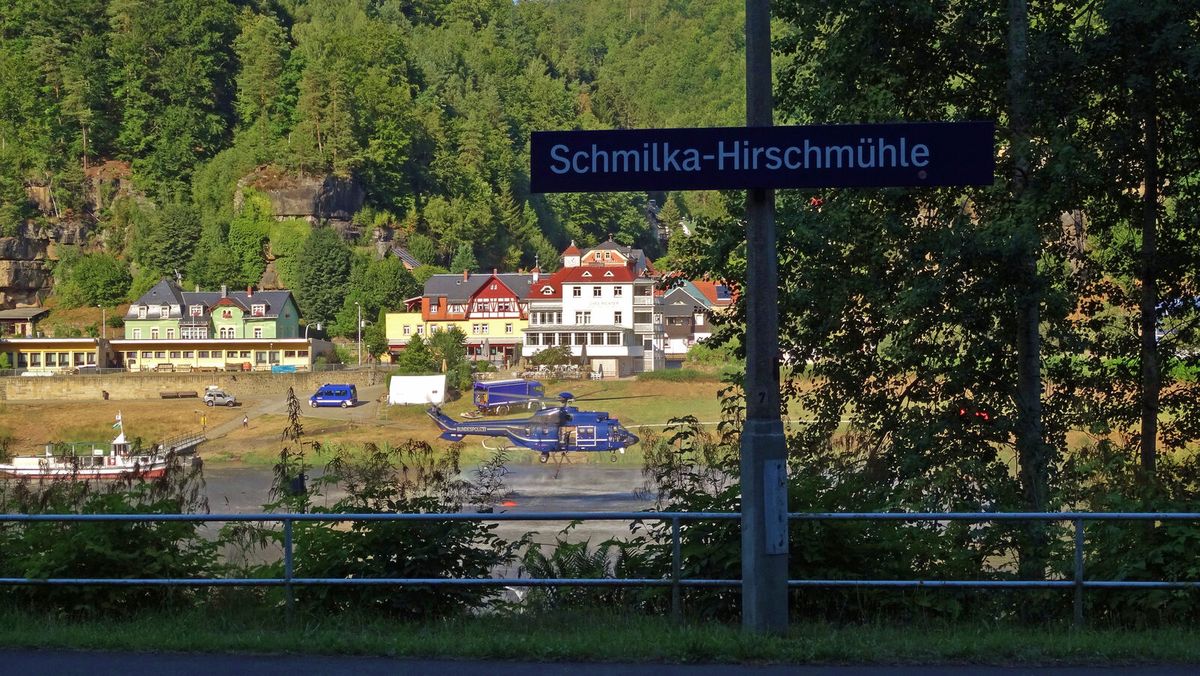 Löschhubschrauber wirft Wasser über einem brennenden Waldgebiet ab