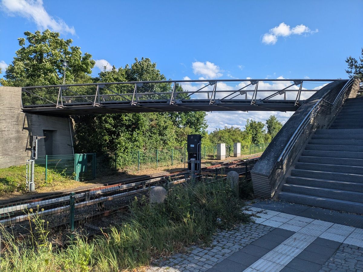 Bahnsteig des U-Bahnhofs Garching-Hochbrück mit Fußgängerbrücke und Aufgang